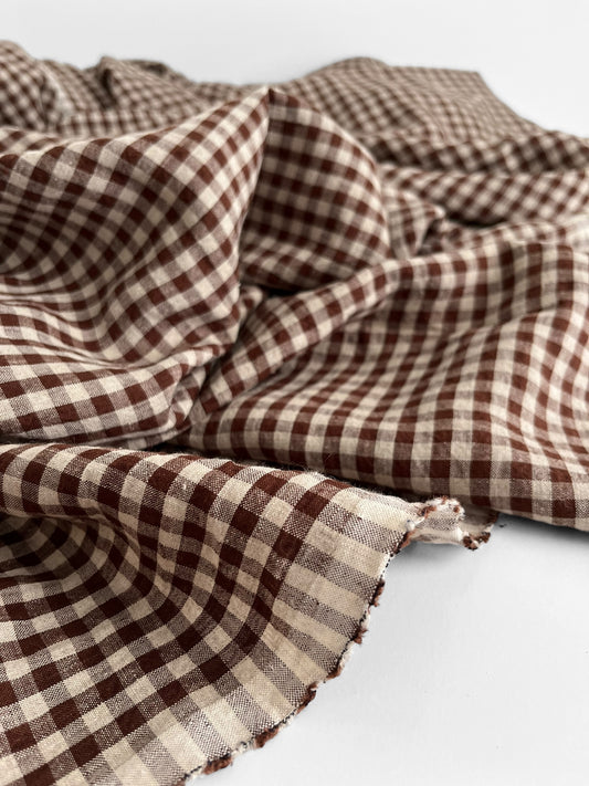 Brown gingham linen fabric on a white background