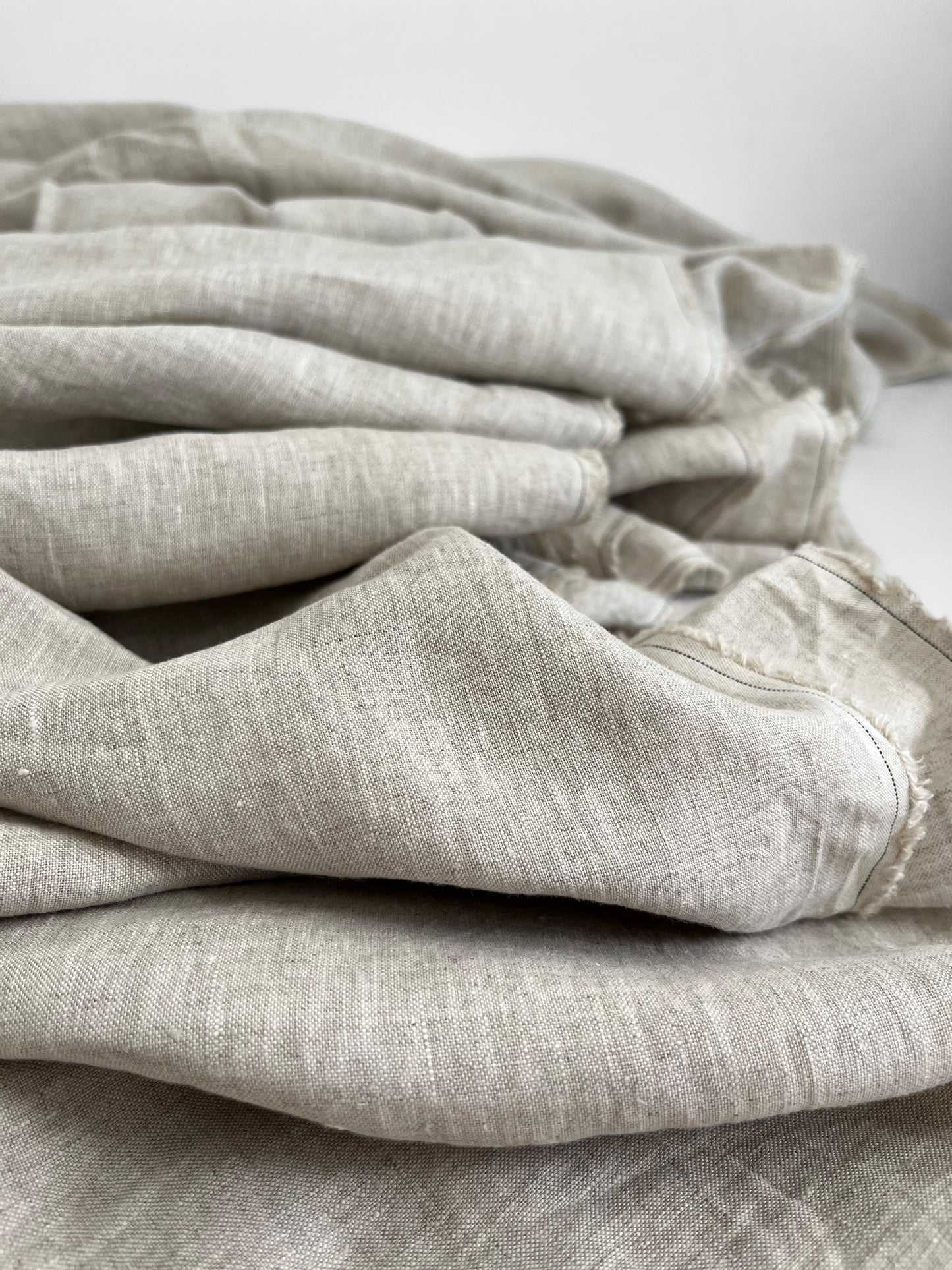 Folded natural linen fabric on a white background