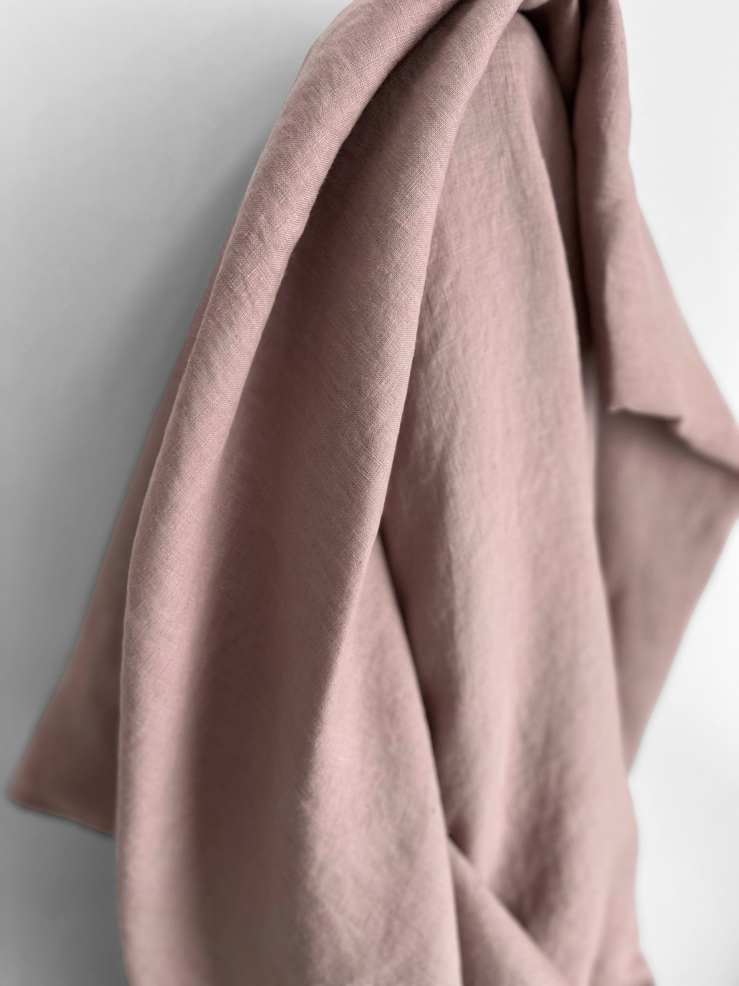 Close-up of a pinkish-brown fabric draped over a surface with a neutral background