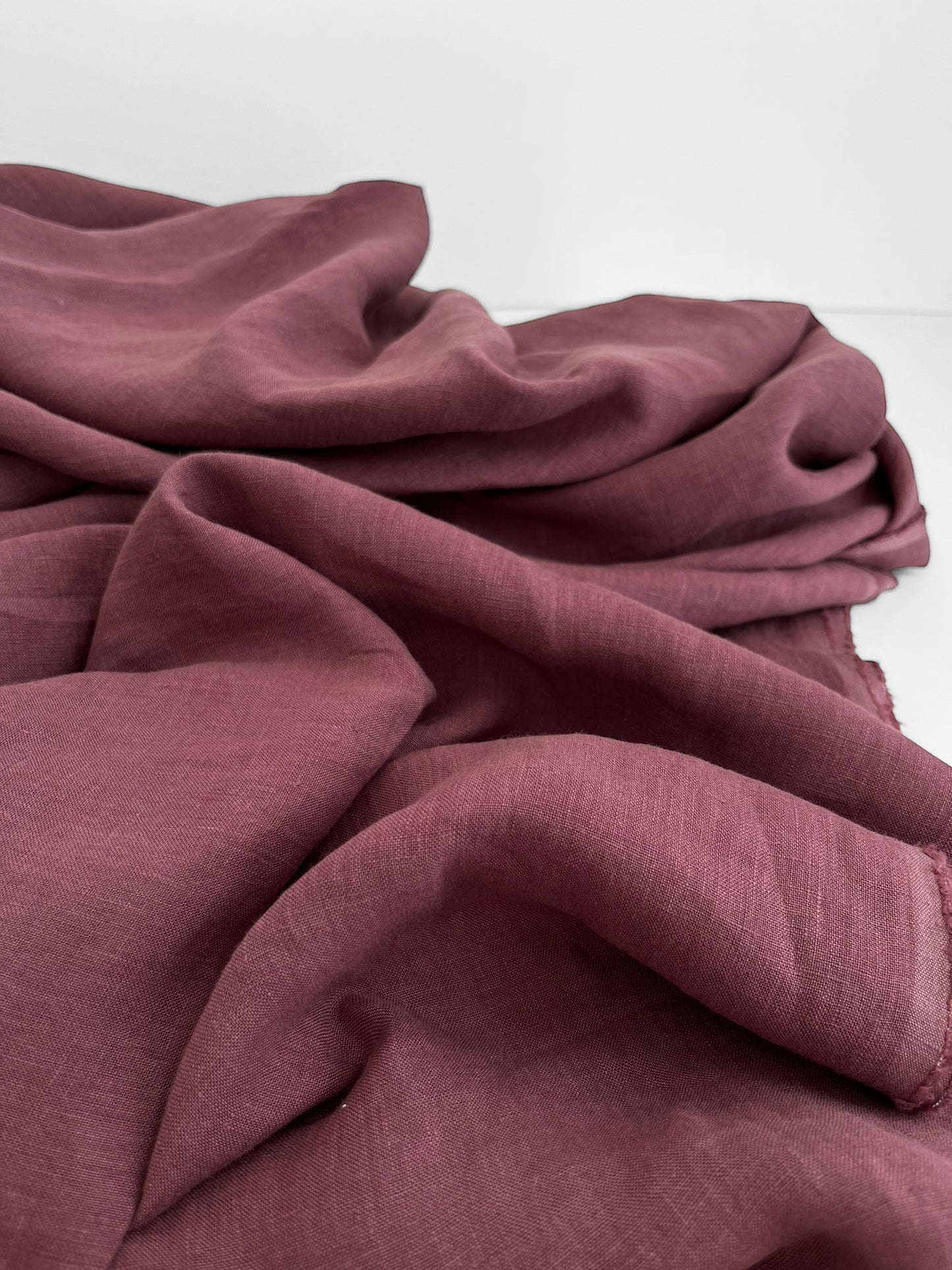 Close-up of a folded purple linen fabric on a white background