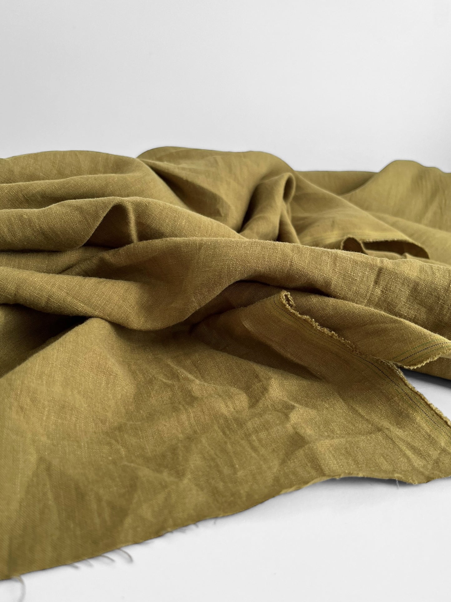 Folded moss green fabric on a white background