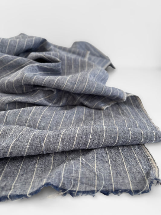 Stack of blue striped linen fabric on a white background