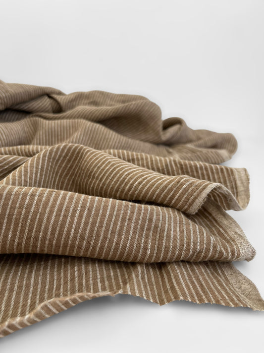 Folded brown fabric with subtle pattern on a white background