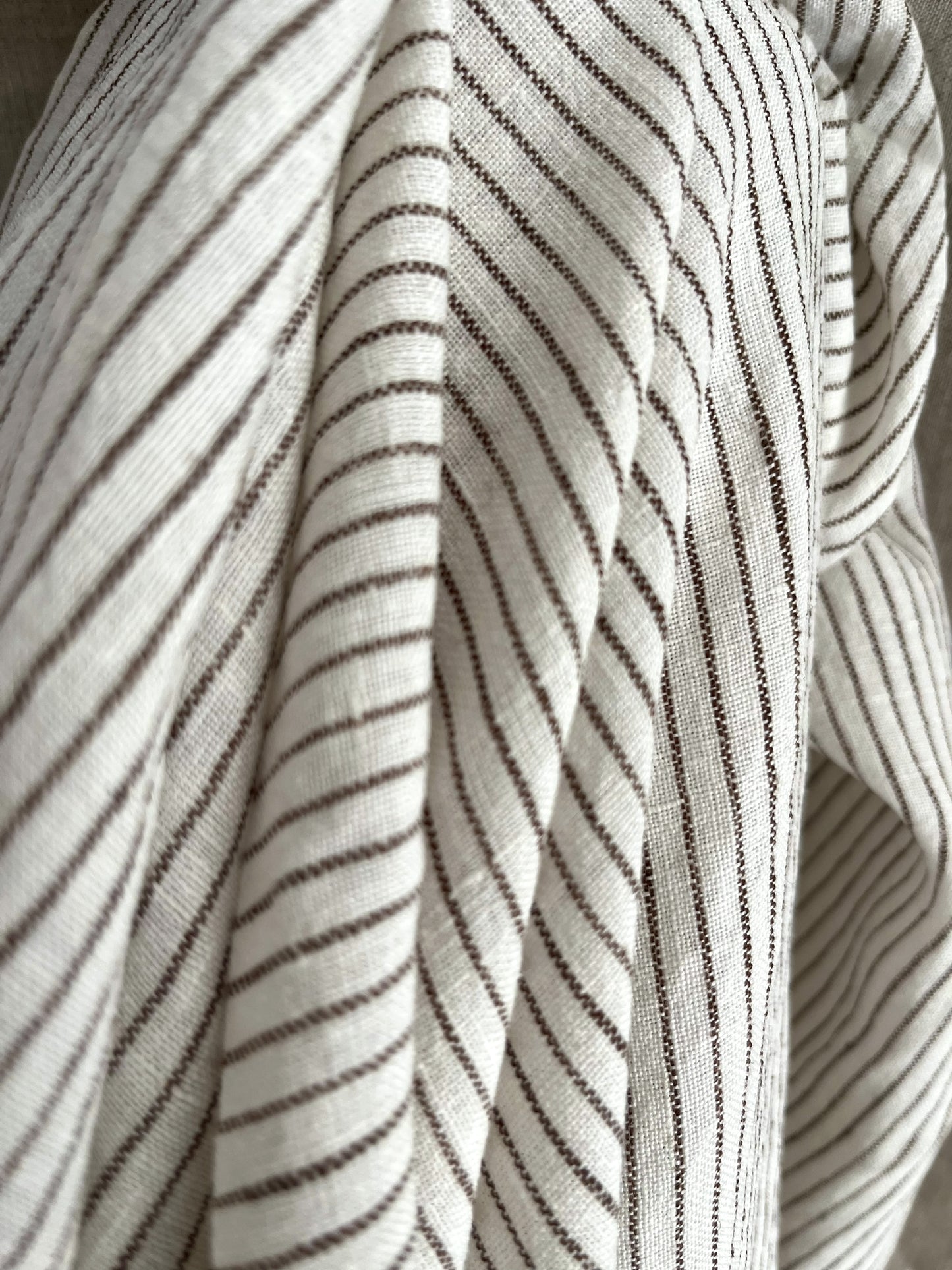 Close-up of striped fabric with thin black lines on a neutral background