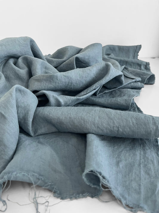 dusty blue linen fabric on a white surface