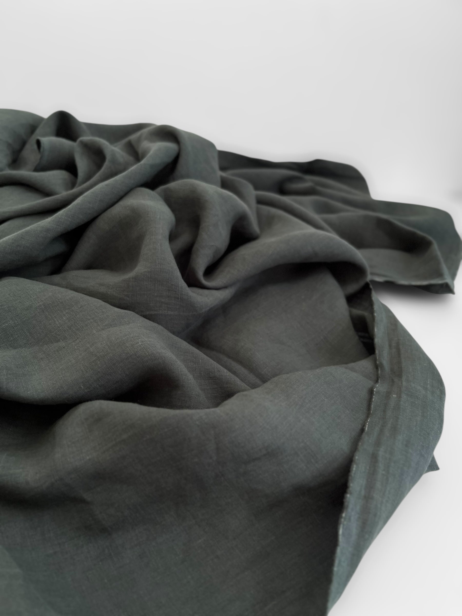 Dark green fabric draped over a white surface