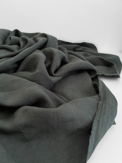 Dark green fabric draped over a white surface