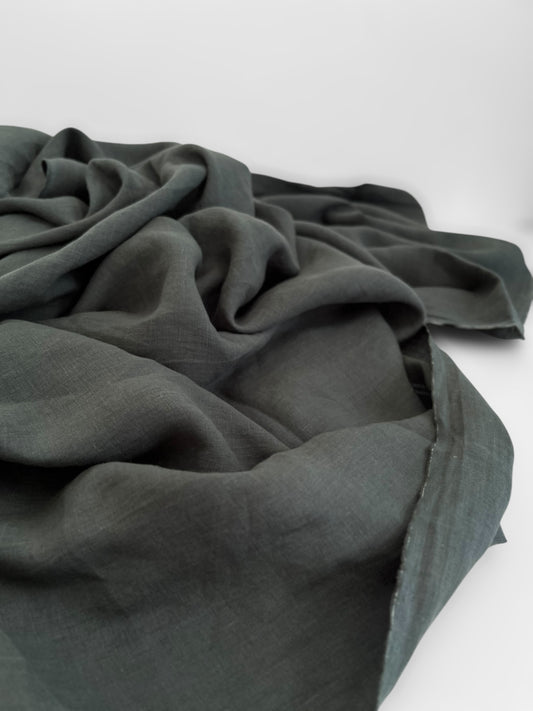 Dark green fabric draped over a white surface