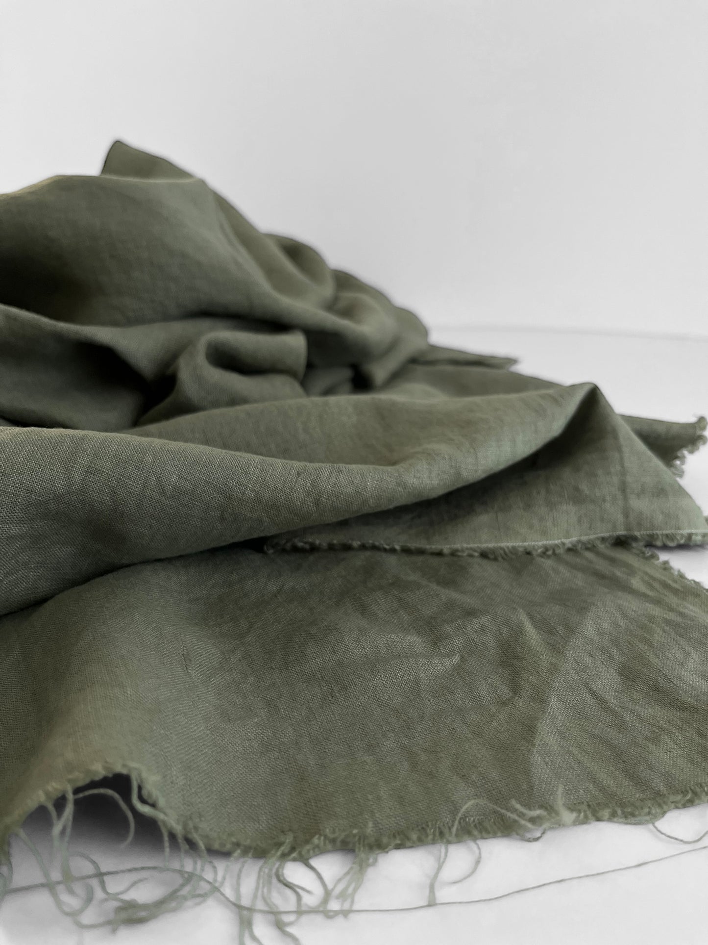 Green fabric with frayed edges on a white background