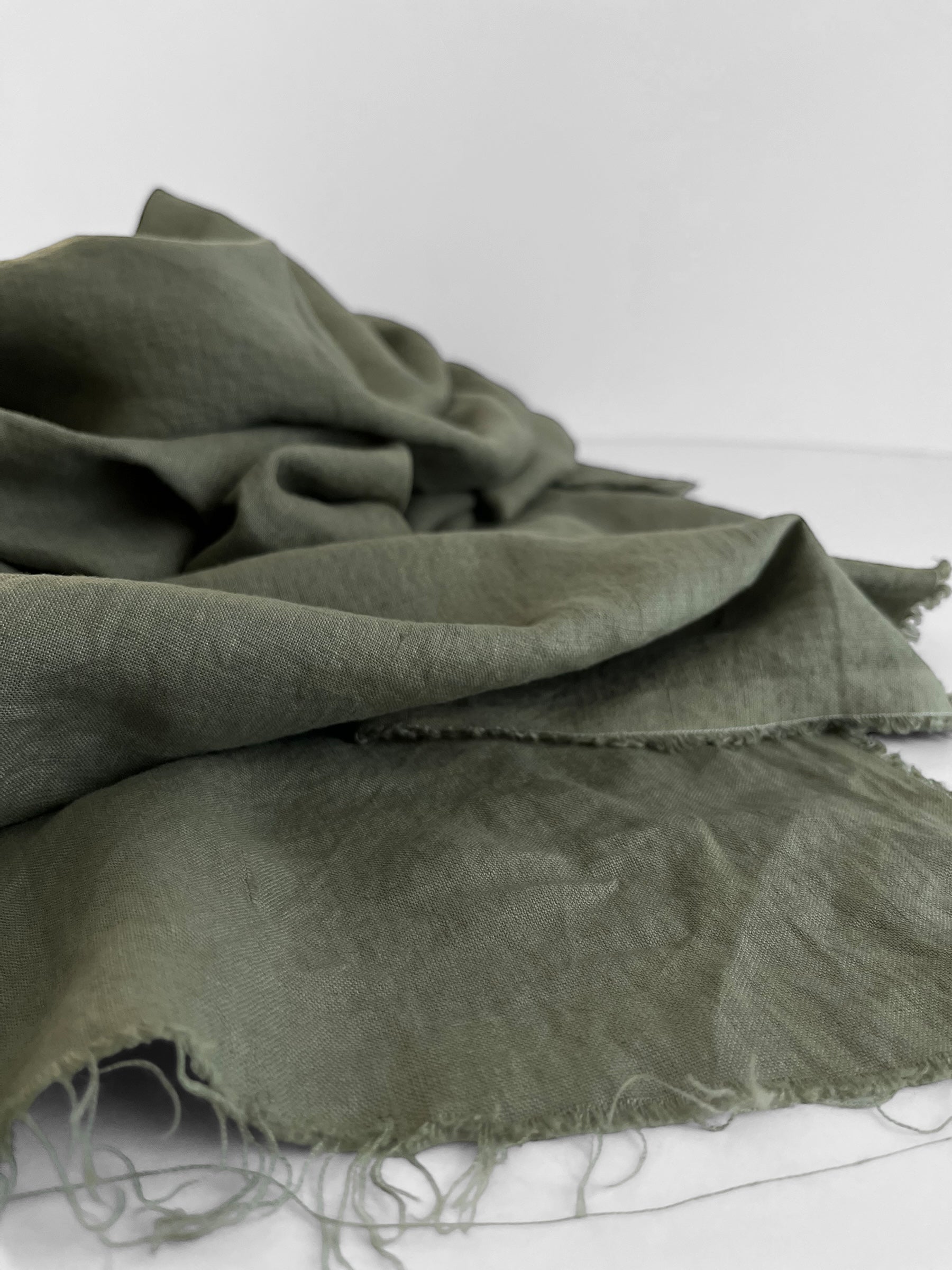 Green fabric with frayed edges on a white background