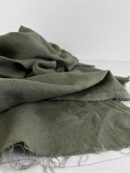 Green fabric with frayed edges on a white background