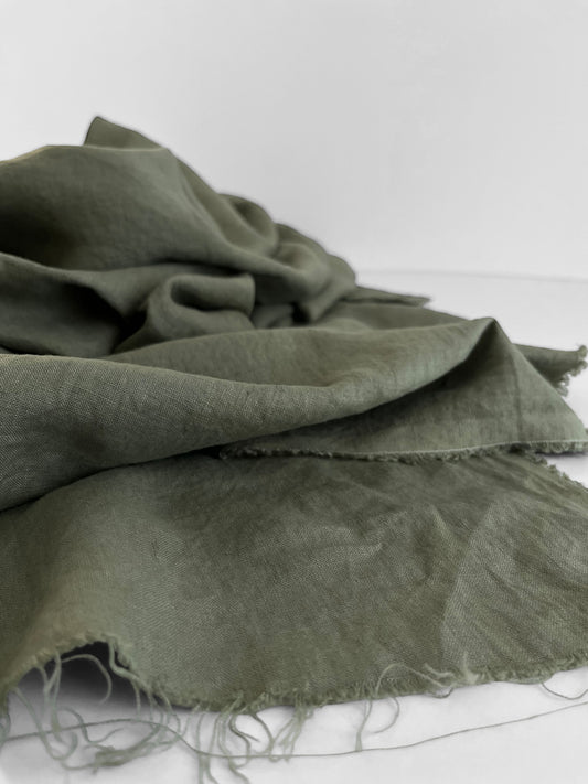 Green fabric with frayed edges on a white background