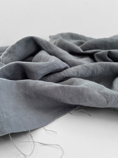 Gray fabric draped over a white surface with a blurred background
