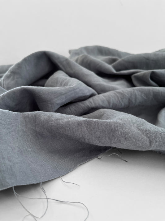 Gray fabric draped over a white surface with a blurred background
